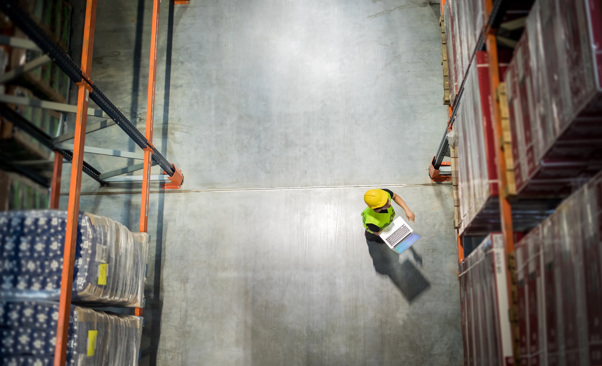 View from above of warehouse worker with laptop at work